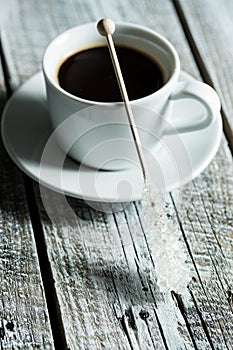 Crystallized sugar on wooden stick and coffee cup.