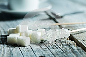 Crystallized sugar on wooden stick and sugar cubes.