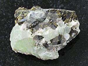 crystals of Epidote on prehnite gemstone on dark