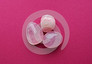 Crystals of rose quartz on a bright pink background. Beautiful semi-precious stones