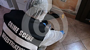 Csi crime scene investigator inspecting with blue flashlights and taking scientific evidence to take to the lab