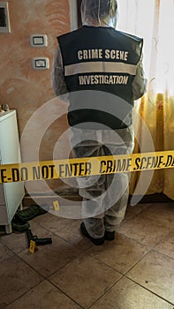 Csi crime scene investigator inspecting with blue flashlights and taking scientific evidence to take to the lab photo