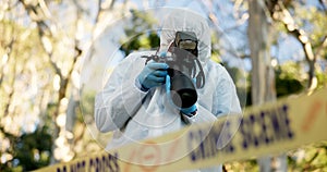 Csi, photographer and police tape at crime scene for investigation in forest with evidence and safety hazmat..Forensic