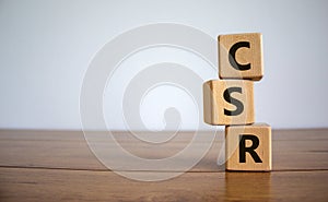 CSR abbreviation on wooden cubes on the wooden table. Corporate Social Responsibility. Beautiful white background with copy space