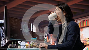 CTO manager in AI startup drinking coffee while coding