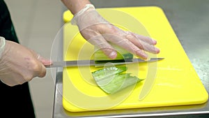 CU: Cook cleverly cuts the skin of the fresh cucumber with a knife.