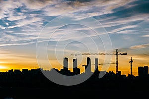 Cuatro Torres Business Area Madrid skyline at sunset with construction cranes and residential buildings photo