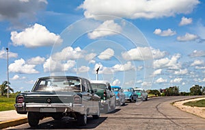 Cuba classic cars lined up drived on the road