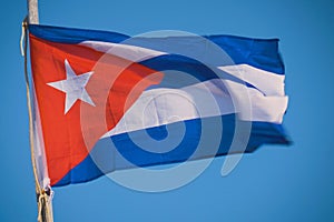 Cuba flag waving in the wind against deep blue sky.