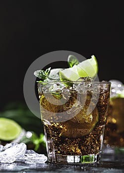 Cuba Libre with brown rum, cola, mint and lime. Cold Longdrink, alcohol cocktail.