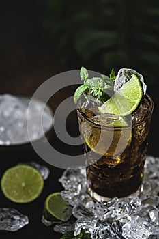 Cuba Libre with brown rum, cola, mint and lime. Cold Longdrink, alcohol cocktail.