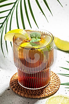 Cuba Libre with rum, cola, mint and lime in the glass on a light background, vertical image. top view. place for text