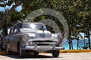 Cuba silver american classic car parked near the beach