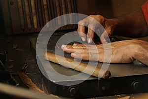 Cuban cigars crafter's hands rolling cigars