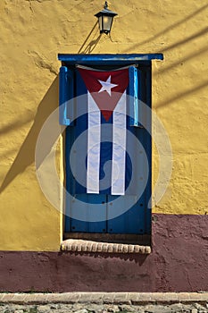 Cuban flag hanging on a door in Trinidad, Cuba