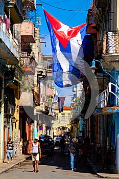 Cuban flags, people and aged buildings in Old Havana