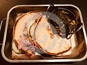 A Cuban sandwich with pita bread and a side of collared greens