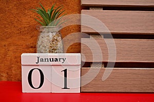 Cube block number 01 and January with wooden frame with red background. New Year Concept