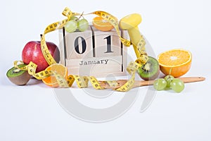 Cube calendar with 1 January, fruits, dumbbells and tape measure, new years resolutions