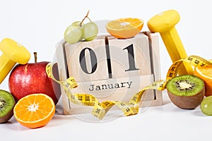 Cube calendar with date 1 January, fruits, dumbbells and tape measure, new years resolutions