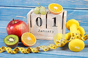 Cube calendar with date of 1 January, fruits, dumbbells and tape measure, new years resolutions