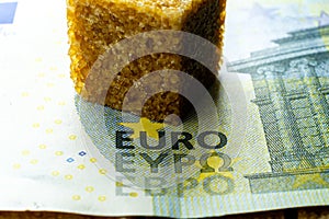 Cube of cane sugar over hubred Euro banknote. World food crisis leds to raising prices for food