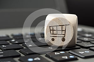 Cube dice on a keyboard with a cart, online shopping