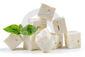 Cube Feta cheese isolated on white background clipping Heap of Feta cheese, basil leaves and tomatoes.