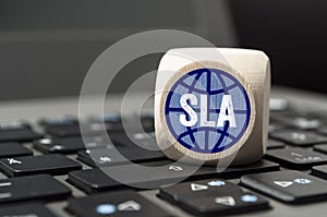 Cube on laptop keyboard with SLA Service-Level-Agreement photo