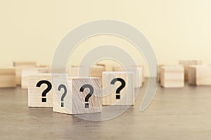 cube with question mark on wooden background. space for text