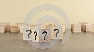 cube with question mark on wooden background. space for text