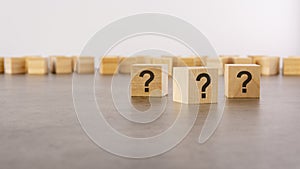 cube with question mark on wooden background. space for text