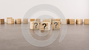 cube with question mark on wooden background. space for text