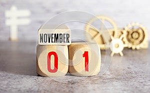 Cube shape calendar for November 01 on wooden surface with empty space for text