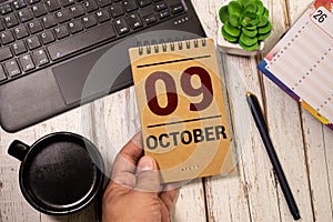 Cube shape calendar for October 09 on wooden surface with empty space for text