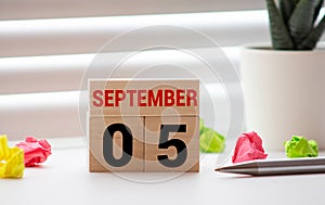 Cube shape calendar for September 05 on wooden surface with empty space for text