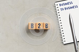 Cubes with acronym B2B and notepad with explanation BUSINESS TO BUSINESS
