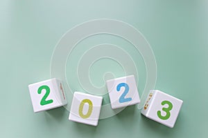 Cubes with colorful numbers 2023 on green background. New year, calendar.