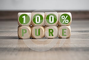 Cubes dice with 100% pure on wooden background