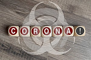 Cubes and dice with biohazard sign and corona-virus on wooden background