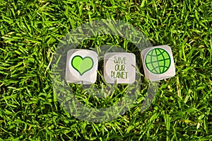 Cubes, dice and black chalkboard with Save our planet and go green