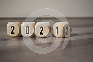 Cubes, dice or blocks with 2021 and 2022 on wooden background