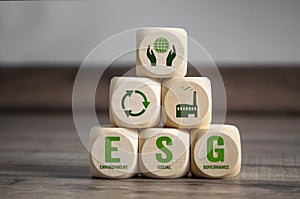 Cubes, dice or blocks with acronym ESG environment social governance on green grass