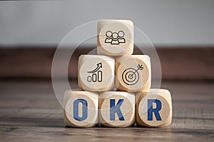 Cubes, dice or blocks with acronym OKR Objective key results on wodden background