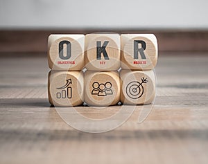 Cubes, dice or blocks with acronym OKR Objective key results on wodden background