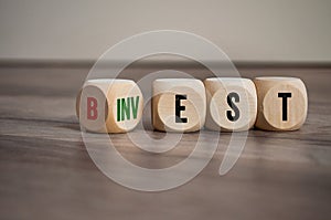 Cubes, dice or blocks with best and invest on wooden background