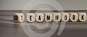 Cubes, dice or blocks with dreamwork and teamwork on wooden background
