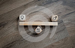 Cubes, dice or blocks with gender pay gap on wooden background