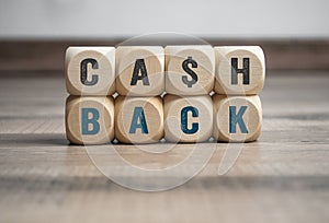 Cubes, dice or blocks with letters cashback on wooden background