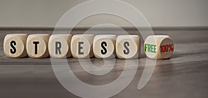 Cubes, dice or blocks with stressfree and stress 100% on wooden background